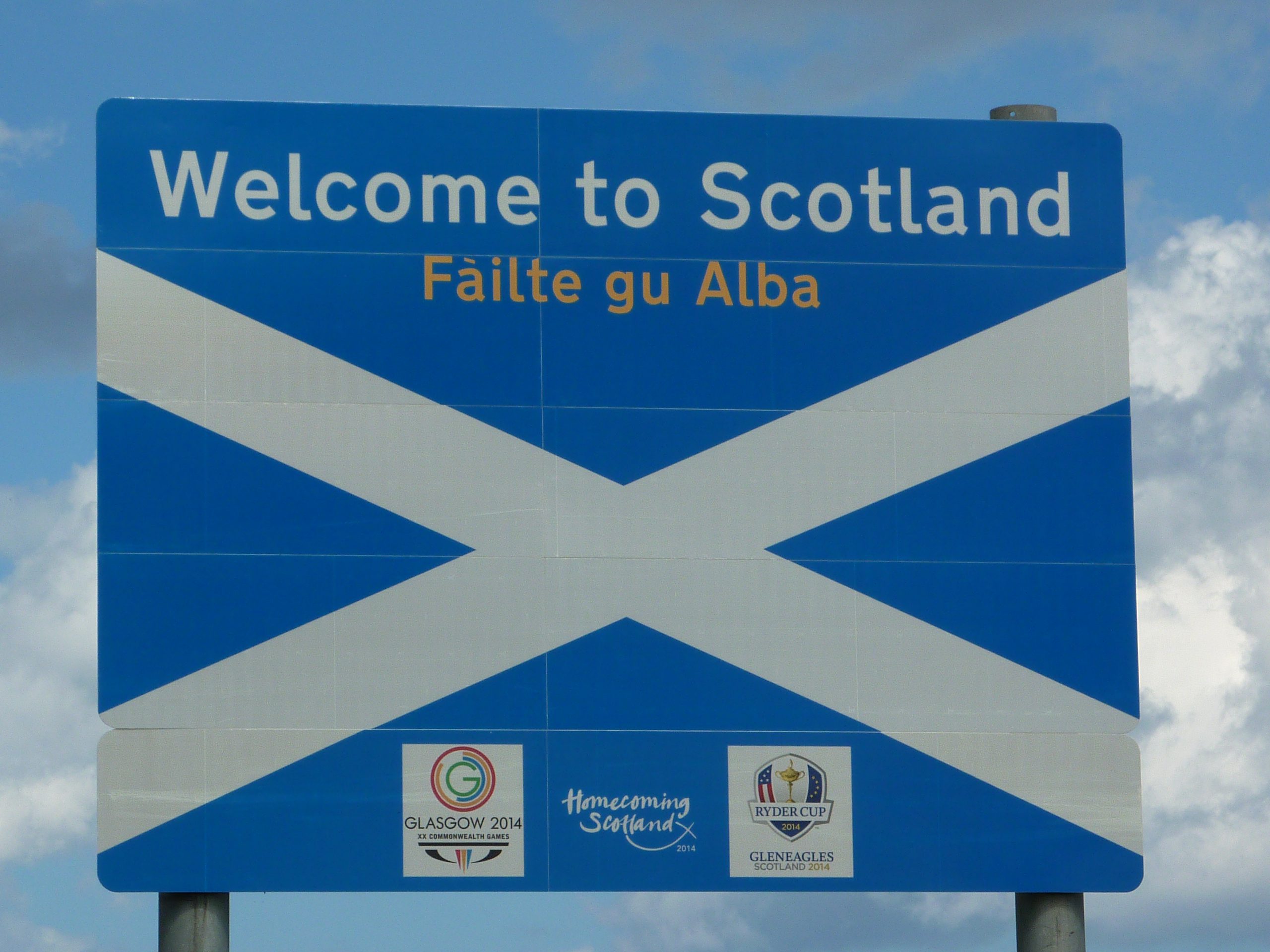 Schild mit der Aufschrift "Welcome to Scotland" und "Fàilte gu Alba" sowie der Schottischen Flagge