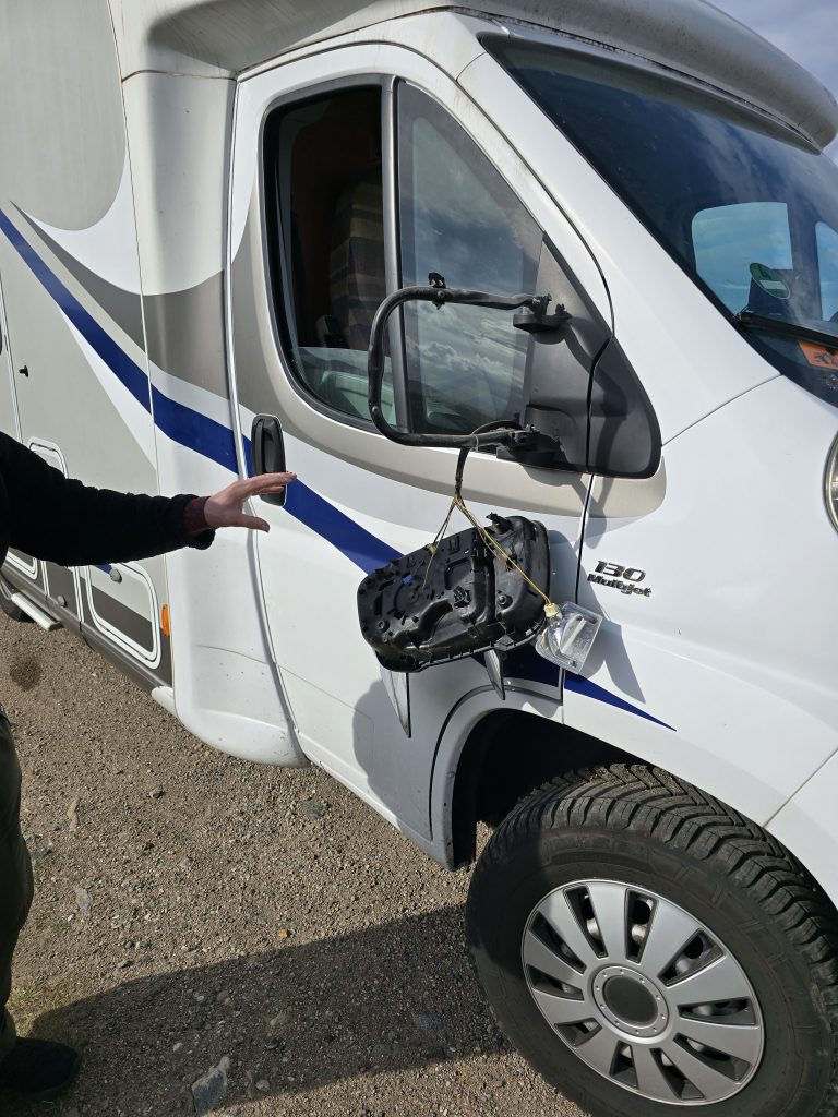 Beifarerseite des Wohnmobils mit herunterhängendem Spiegel